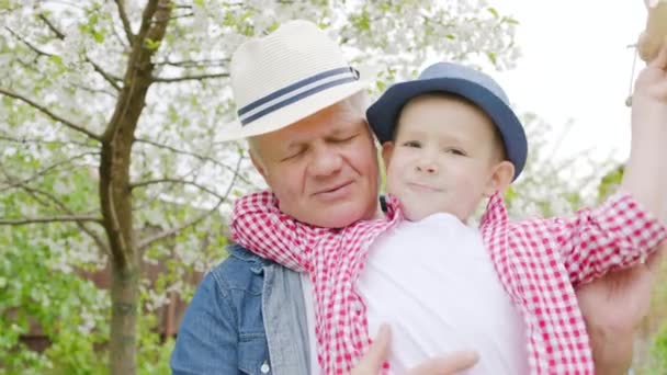 Dziadek i wnuk grając w kwitnący ogród na farmie - Materiał filmowy, wideo