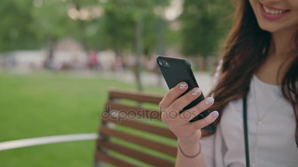 Krásná bruneta pomocí mobilní telefon venku - Záběry, video