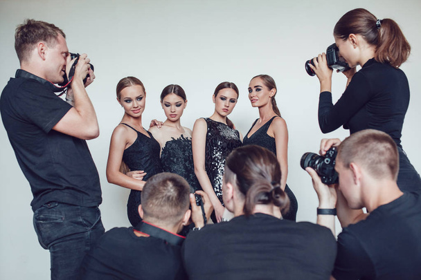 Photographers paparazzi take photos of women in cocktail dresses. - Fotó, kép