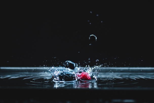rijpe bessen vallen in water - Foto, afbeelding