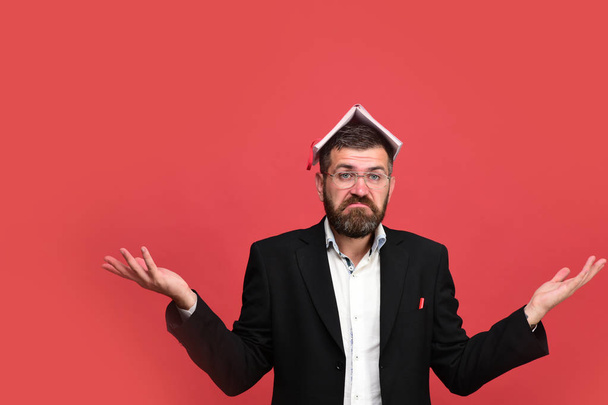 Man in classic outfit with beard holds book on head - Фото, изображение