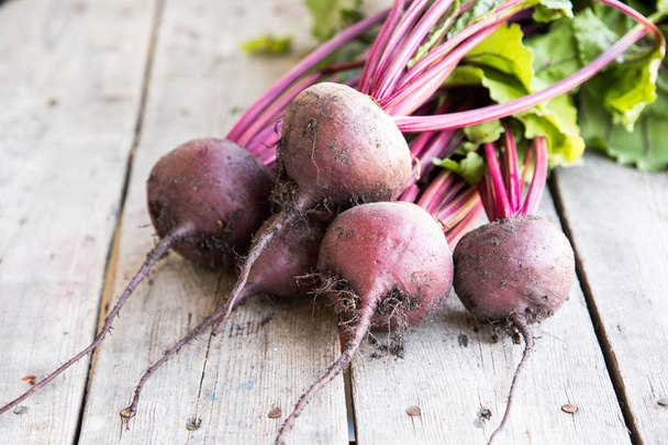 Red Beetroot with herbage green leaves on rustic background.  - Фото, зображення