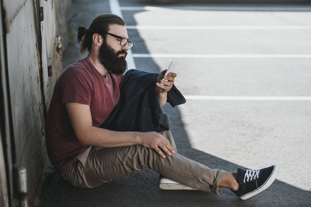 man sitting on floor and using phone - Photo, Image