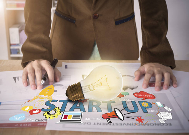Travailleur d'affaires avec ampoule sur le bureau. concept start-up
 - Photo, image
