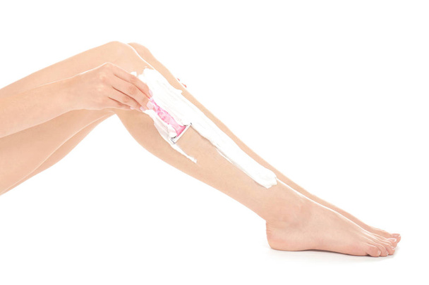 Young woman shaving leg  - Foto, afbeelding