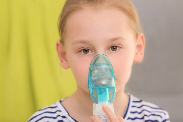 Girl using asthma machine on blurred background - Foto, afbeelding