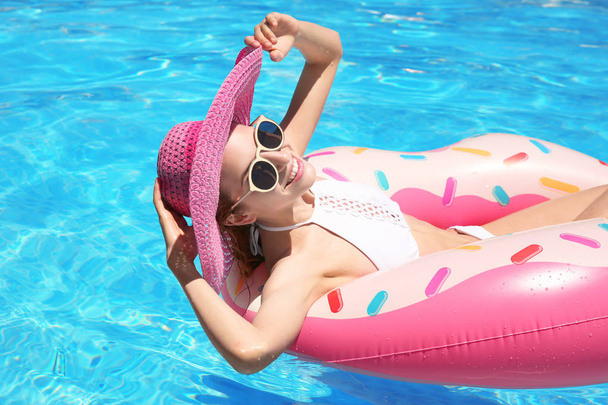 Beautiful young woman with inflatable donut  - Photo, Image