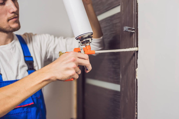 Young handyman installing door  - Fotoğraf, Görsel