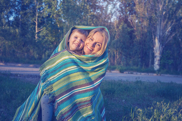 Gelukkig jonge moeder en haar dochtertje in een park - Foto, afbeelding