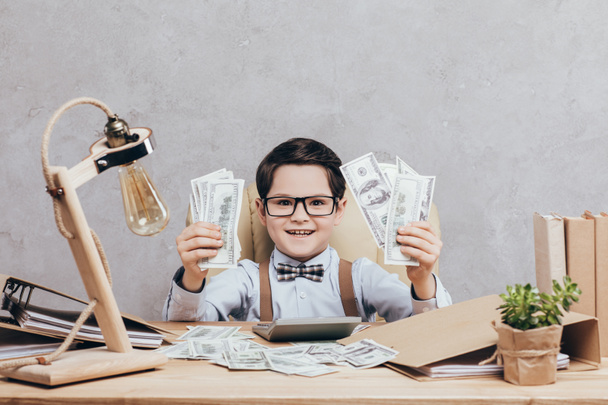 niño emocionado con dinero en efectivo en el lugar de trabajo
 - Foto, Imagen