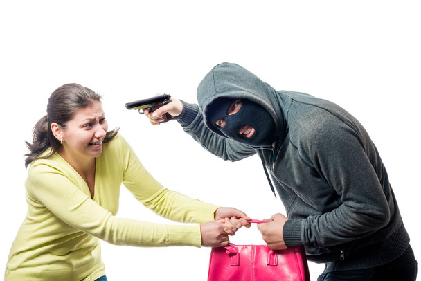 Ladrón callejero en un pasamontañas con un arma roba la bolsa de una mujer, sho
 - Foto, Imagen