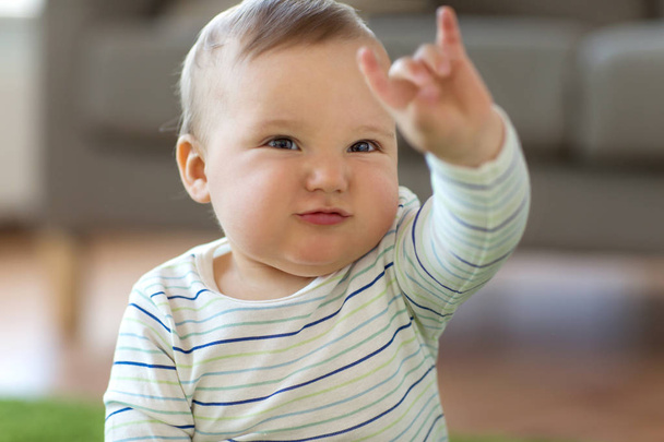 baby boy showing rock hand sign at home - Foto, imagen