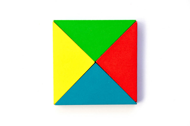 Bloque de juguete colorido de madera en forma de triángulo para construir un diseño cuadrado sobre fondo blanco
 - Foto, imagen