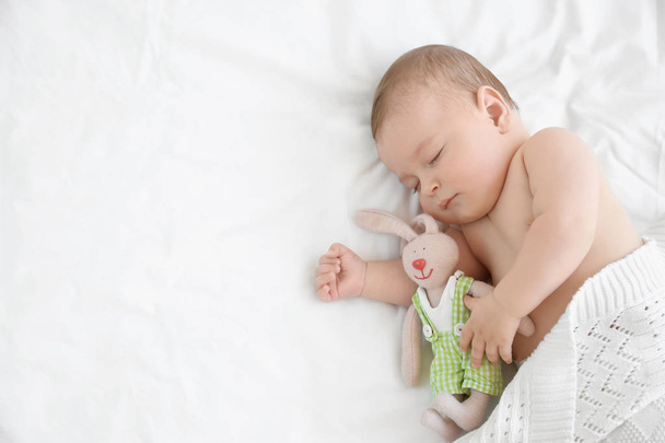 Söpö pieni vauva lelu nukkuu sängyssä kotona
 - Valokuva, kuva