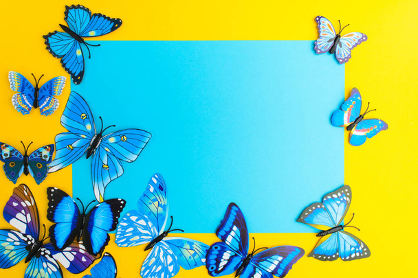 Blue paper with butterfly decoration on yellow background with c - Foto, immagini