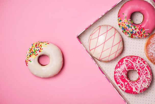 Donuts with icing on pastel pink background. Sweet donuts. - Photo, Image