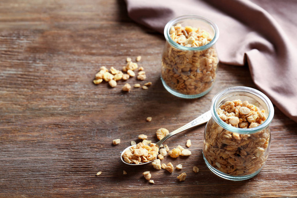 Healthy breakfast cereal in glass jars on wooden background - Foto, imagen
