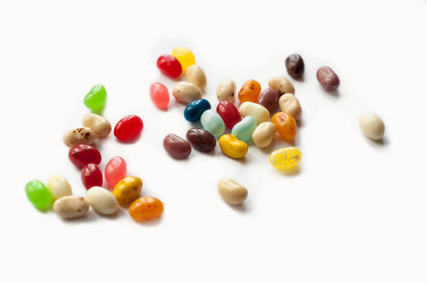 Felgekleurde snoep bonen. Kleurrijke jelly bean achtergrond. Jelly beans geïsoleerd op witte achtergrond. - Foto, afbeelding