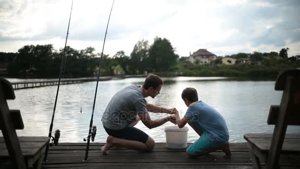 Beztroski tata i syn, przygotowanie do połowów na jeziorze - Materiał filmowy, wideo