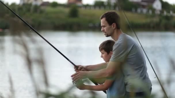 Baba ve oğlu Balık tutma ve gölette rahatlatıcı gülümseyen - Video, Çekim