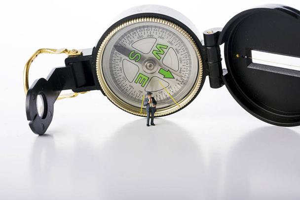 Miniature people business man on compass over white background - Foto, Imagen