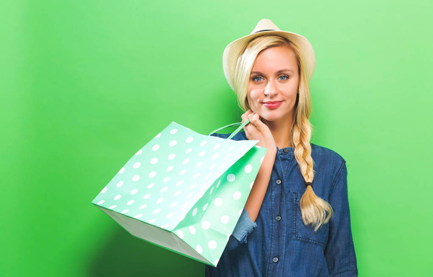 Happy young woman holding a shopping bag - Photo, Image