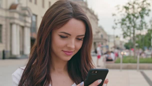 Egy gyönyörű barna használatával egy mobil telefon a szabadban - Felvétel, videó