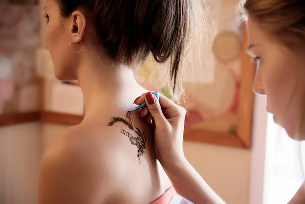 Girl painting mehendi on back of client - Zdjęcie, obraz