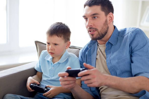 father and son playing video game at home - Foto, immagini