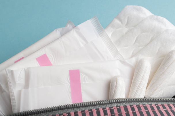 Menstruatietampons en -kussens in cosmetische zak. Menstruatiecyclus. Hygiëne en bescherming - Foto, afbeelding