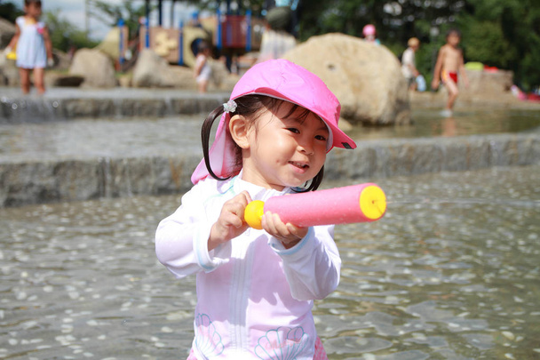 Japonés jugando con pistola de agua (2 años)
) - Foto, imagen