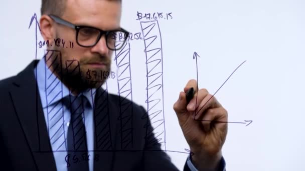 Muž čerpá různé růstové grafy, výpočet vyhlídky na úspěch v kanceláři moderního skla - Záběry, video