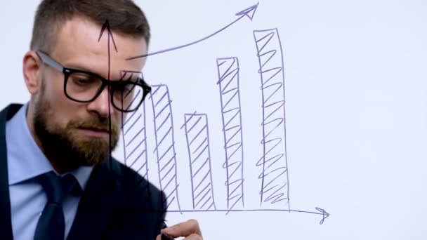L'homme dessine différents graphiques de croissance, calculant les perspectives de succès dans un bureau en verre moderne
 - Séquence, vidéo