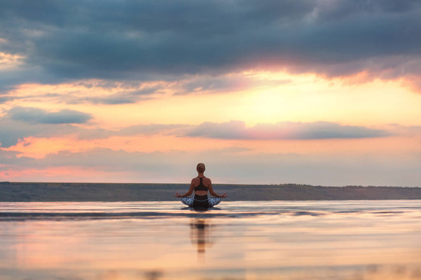 Bella donna che fa yoga al tramonto all'aperto
 - Foto, immagini