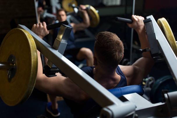 man doing chest press on exercise machine in gym - Photo, Image
