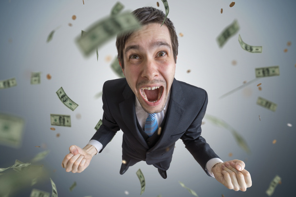 Young successful businessman is a winner. Money are falling from - 写真・画像