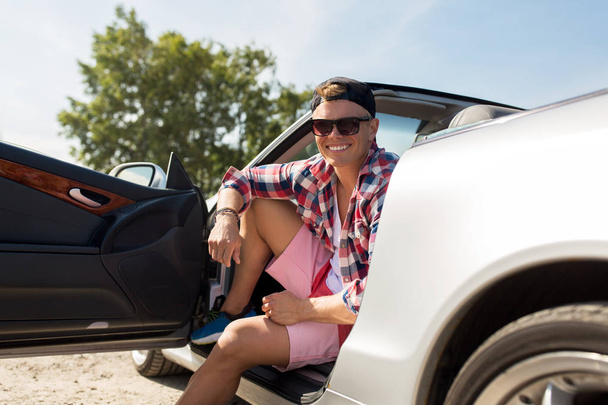 счастливый молодой человек, сидящий в перевернутой машине
 - Фото, изображение