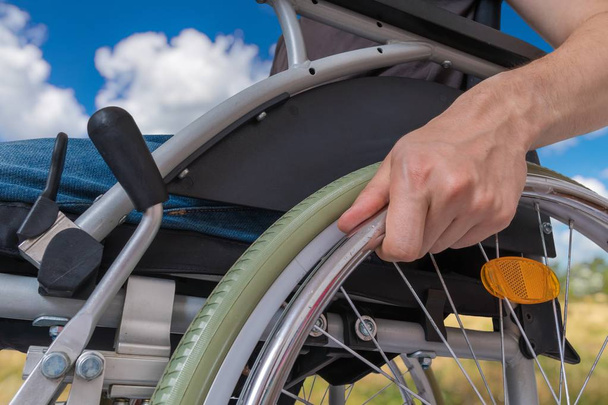 deficiente deficiente homem sentado em cadeira de rodas ao ar livre no meado
 - Foto, Imagem