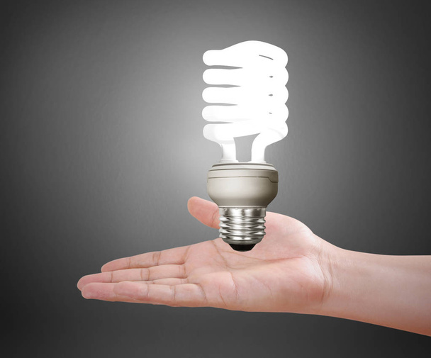 hand holding a light bulb with energy  - Foto, afbeelding