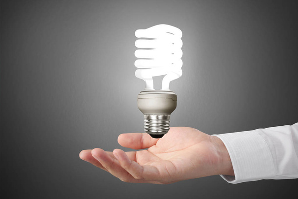 hand holding a light bulb with energy  - Fotó, kép