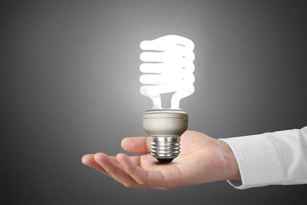 hand holding light bulb with energy  - Foto, imagen