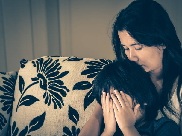 Estilo retro de niño triste siendo abrazado por su madre en casa. Concepto de paternidad, amor y unión
. - Foto, imagen