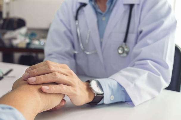 Close up of doctor touching patient hand for encouragement and e - Photo, Image