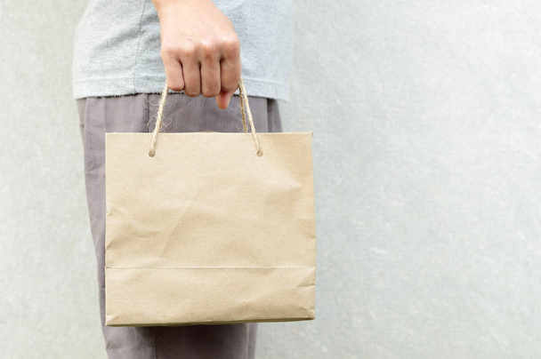 woman holding blank brown paper bag package - Foto, Imagen