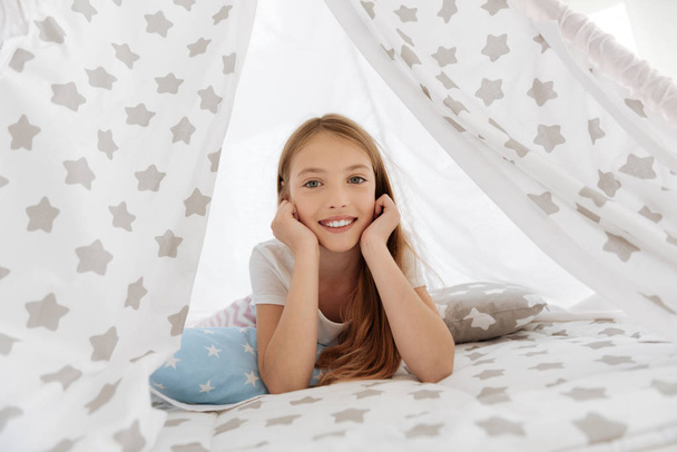 Happy child lying in teepee and looking into camera - Fotoğraf, Görsel