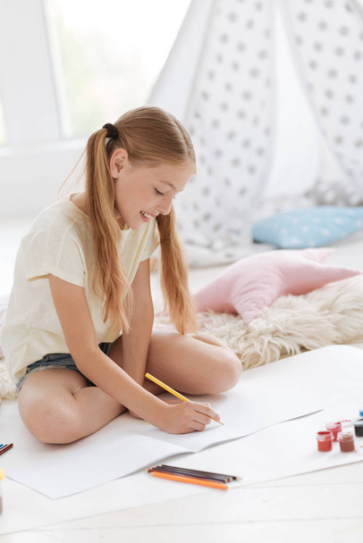 Cheerful girl enjoying drawing - Fotografie, Obrázek