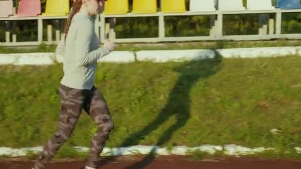 Athlete woman waiting in the starting block on running track 4k - Video, Çekim