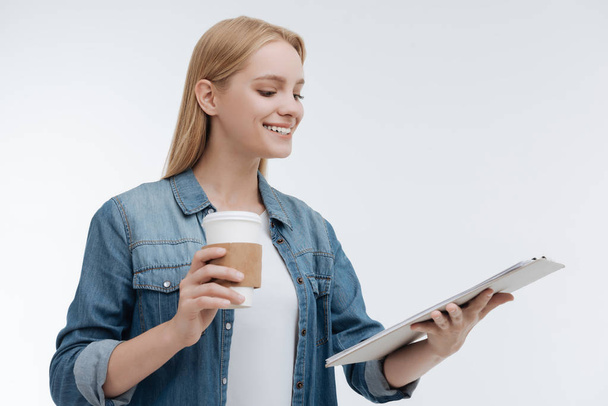 Cheerful young female holding paper cup in right hand - Foto, Bild