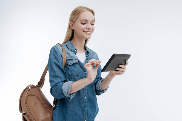 Attractive smiling woman looking at her tablet - Photo, image