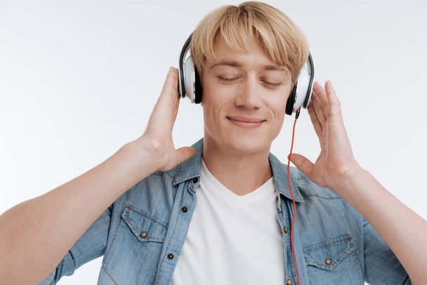 Relaxed light-haired man enjoying favorite music - Foto, imagen